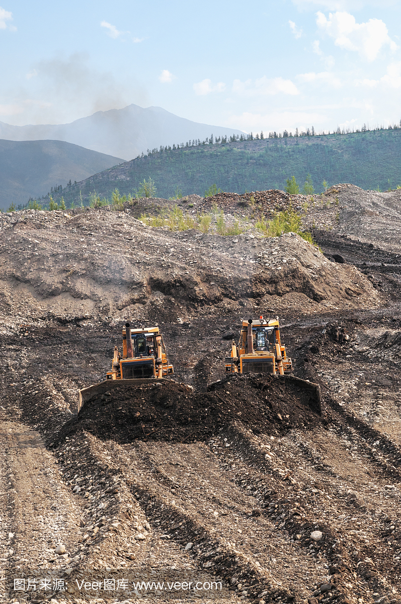 推土机将山区的金砂耙成一堆,用于后续的工业洗矿专用设备